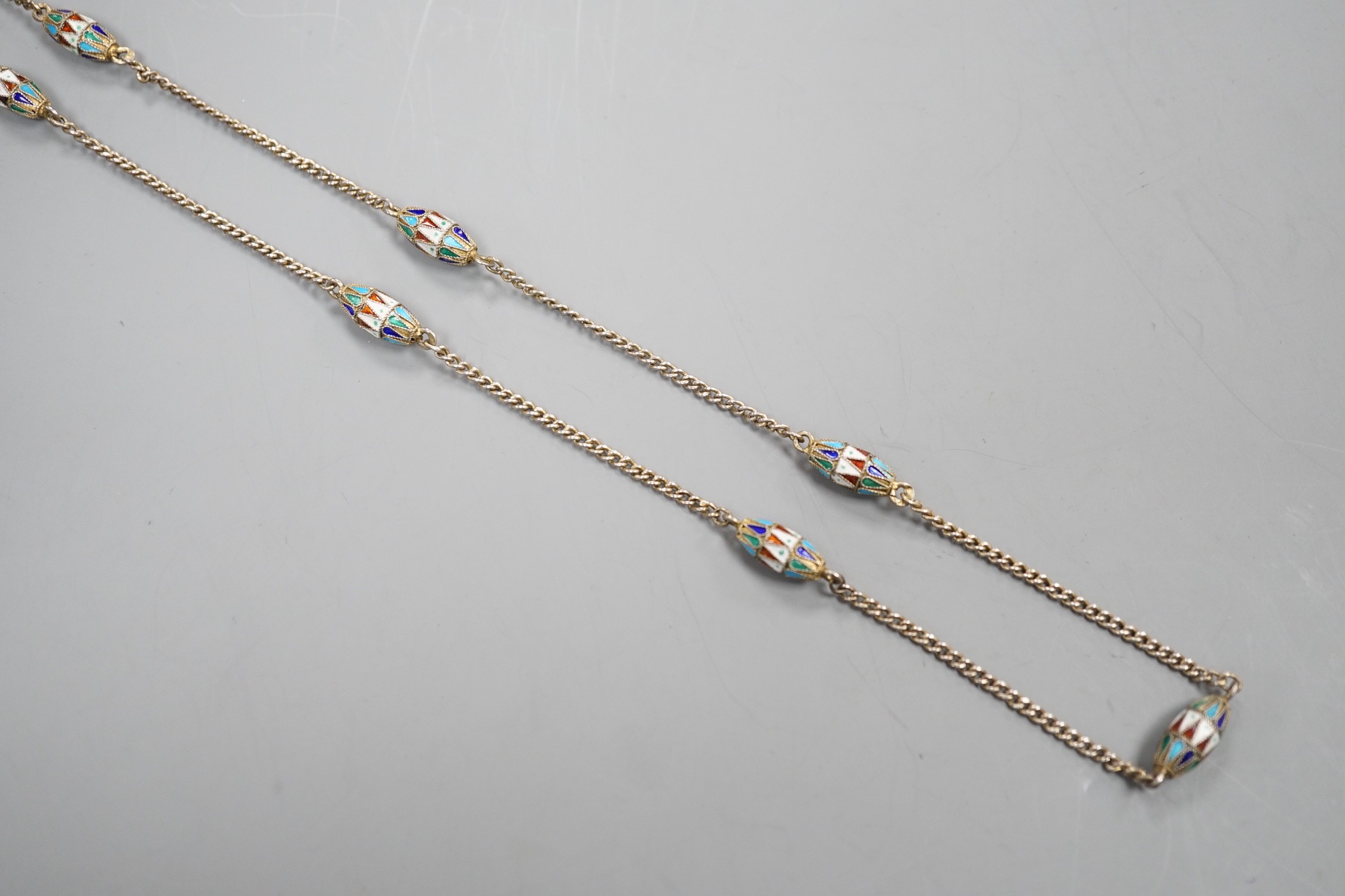 An early 20th century Russian 84 zolotnik and polychrome cloisonné enamel necklace, set with thirteen torpedo shaped enamelled links, 94cm.